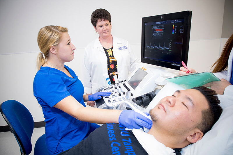 Technician doing a sonography on a male patient