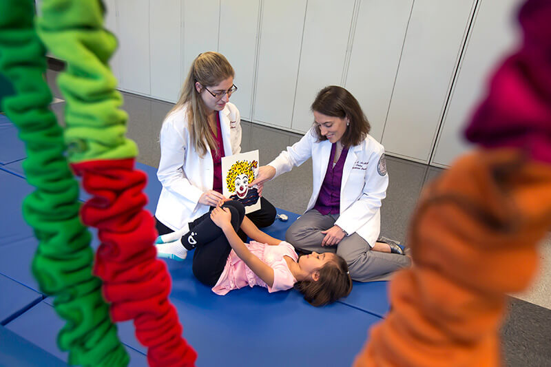 two occupational therapists with child